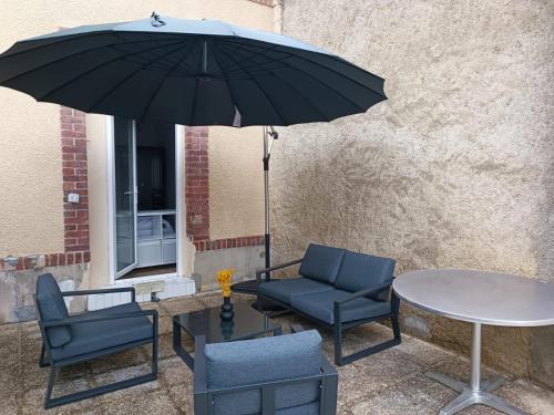 een tafel en twee stoelen en een tafel met een parasol bij El verde in Épernay