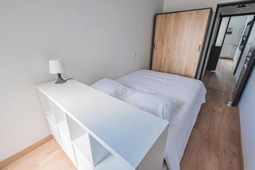 een slaapkamer met een wit bed en een bureau bij El verde in Épernay