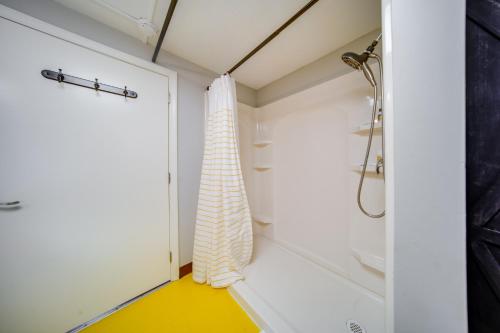 a bathroom with a shower and a yellow floor at The Little Giant, Converted Railcar in DuBois! in Adrian Furnace