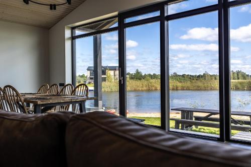 a room with a table and chairs and a large window at Lielpīles in Radziņciems