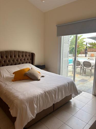 a bedroom with a bed and a sliding glass door at Sunset Bungalow in Paphos City