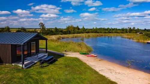 a small cabin on the shore of a river at Lielpīles in Radziņciems