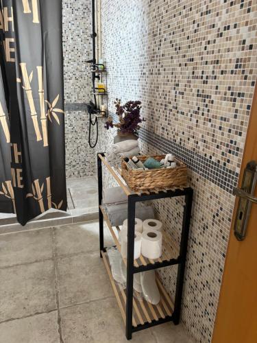 a bathroom with a shelf with towels and a shower at Sunset Bungalow in Paphos City
