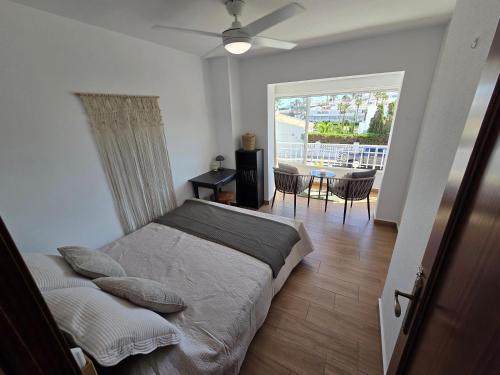 a bedroom with a bed and a balcony with a table at "Ancla-Blanca" Ocean View Duplex 2min Beach Cabo Roig - La Zenia in Orihuela Costa
