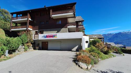 a large building with a parking lot in front of it at Centre Thermal - Studio SUD terrasse in Ovronnaz
