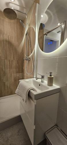 a white bathroom with a sink and a mirror at Apartamenty Natural in Drawsko Pomorskie