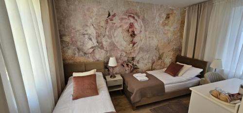 a hotel room with two beds and a painting on the wall at Apartamenty Natural in Drawsko Pomorskie