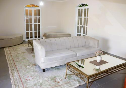 a living room with a white couch and a coffee table at Hotel Nova Sorocabana in Brodósqui
