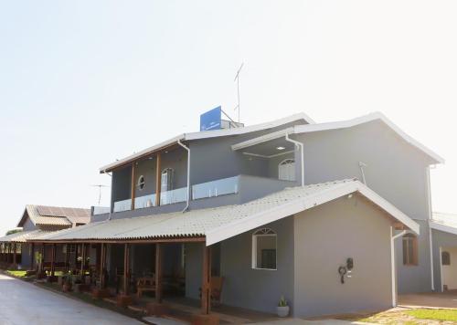 a large white building with a roof at Hotel Nova Sorocabana in Brodósqui