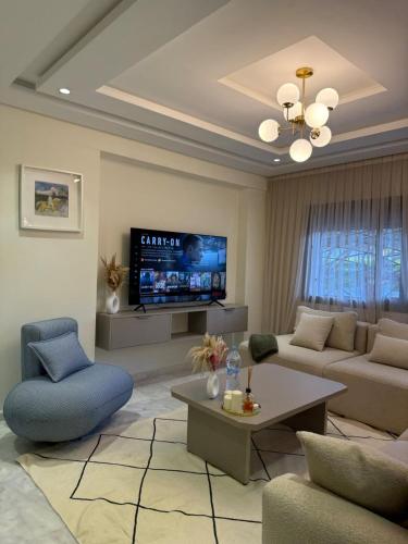 a living room with a couch and a tv at Cozy apartment Beach and Souk within walking distance in Tangier