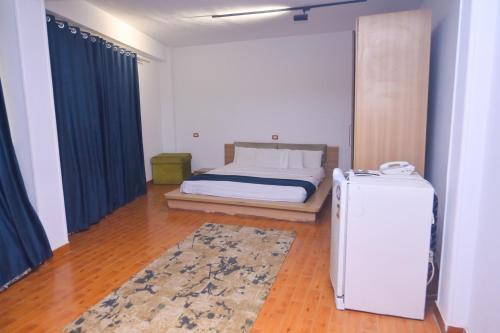 a bedroom with a bed and a refrigerator in it at New Alhussien Hotel in Asyut