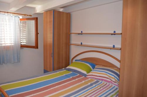 a bedroom with a bed with a wooden headboard at Apartment Borna in Baška