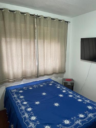 ein Schlafzimmer mit einem blauen Bett mit blauer Decke in der Unterkunft Apartamento inteiro in Porto Alegre