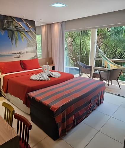 a bedroom with two beds and a table and chairs at Villas do Pratagy in Maceió