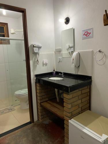 a bathroom with a sink and a toilet at Pousada Caminho do Vale Guiné in Mucugê