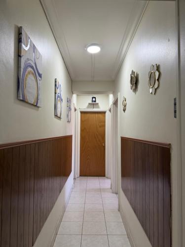 a hallway with a wooden door in a building at Departamentos Familiares Santiago de Chile in Santiago