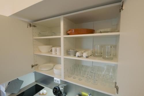 een keukenkast gevuld met glazen en borden bij Rosa Garden Retreat in São Roque