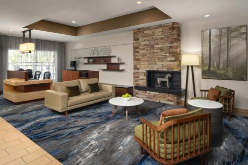 a living room with a couch and a fireplace at Fairfield Inn Orlando Airport in Orlando