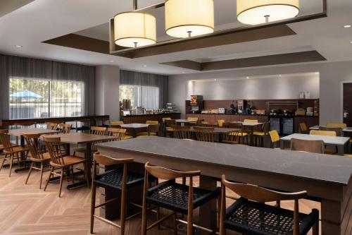 a restaurant with tables and chairs and a bar at Fairfield Inn Orlando Airport in Orlando