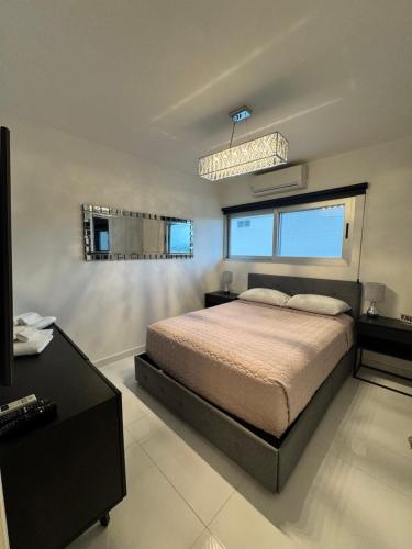 a bedroom with a bed and a desk and windows at Dominik luxury penthouse in Cancún