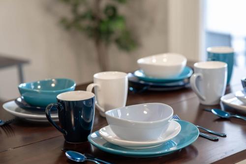 a wooden table with blue plates and cups and spoons at Relaxing Place Close to Skiing in Midvale