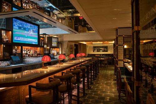 a bar with a row of bar stools in a restaurant at MOXY NYC Times Square in New York