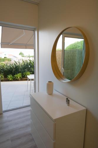 a mirror on a wall in a room with a dresser at Rosa Garden Retreat in São Roque