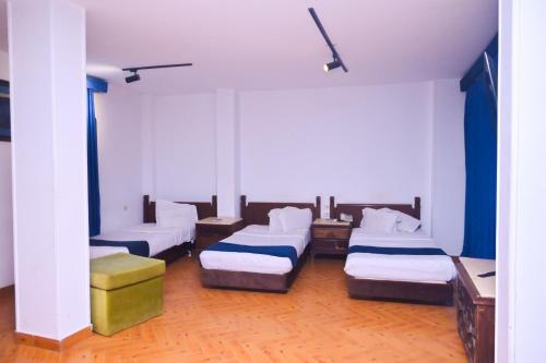 a room with four beds in a room at New Alhussien Hotel in Asyut