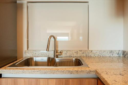 a kitchen counter with a sink and a mirror at Yucalpeten Resort Marina - Dpto de 2 Recámaras en Progreso - Lujo Frente a la Playa & Amenidades Top in Progreso