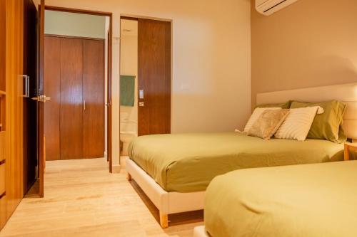 a hotel room with two beds and a bathroom at Yucalpeten Resort Marina - Dpto de 2 Recámaras en Progreso - Lujo Frente a la Playa & Amenidades Top in Progreso