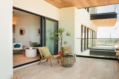 a living room with two chairs and a large window at Yucalpeten Resort Marina - Dpto de 2 Recámaras en Progreso - Lujo Frente a la Playa & Amenidades Top in Progreso