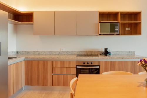 a kitchen with wooden cabinets and a wooden table at Yucalpeten Resort Marina - Dpto de 2 Recámaras en Progreso - Lujo Frente a la Playa & Amenidades Top in Progreso
