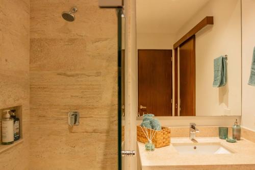 a bathroom with a sink and a mirror at Yucalpeten Resort Marina - Dpto de 2 Recámaras en Progreso - Lujo Frente a la Playa & Amenidades Top in Progreso