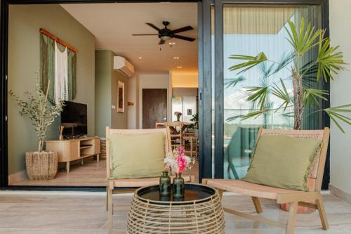 a living room with two chairs and a table at Yucalpeten Resort Marina - Dpto de 2 Recámaras en Progreso - Lujo Frente a la Playa & Amenidades Top in Progreso