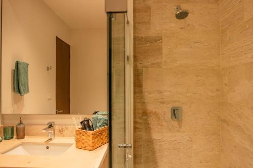 a bathroom with a shower with a sink and a mirror at Yucalpeten Resort Marina - Dpto de 2 Recámaras en Progreso - Lujo Frente a la Playa & Amenidades Top in Progreso