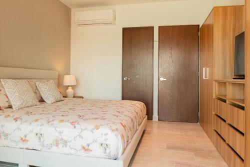 a bedroom with a bed and a wooden cabinet at Yucalpeten Resort Marina - Dpto de 2 Recámaras en Progreso - Lujo Frente a la Playa & Amenidades Top in Progreso
