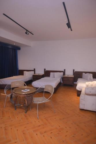 a room with couches and a table and chairs at New Alhussien Hotel in Asyut