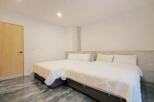 a bedroom with a large bed with white sheets at House16 in Green Island