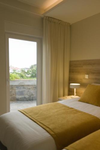 a bedroom with a large bed and a large window at Rosa Garden Retreat in São Roque