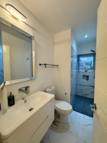 a bathroom with a sink and a toilet and a shower at Dominik luxury penthouse in Cancún