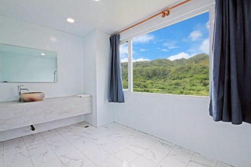 a bathroom with a sink and a large window at House16 in Green Island