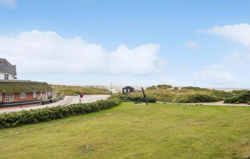 a person walking down a road next to a house at Awesome Apartment In Fanø With Sauna in Fanø