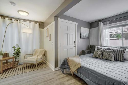 a bedroom with a bed and a chair and a window at Euro Cottage - Downtown Convenience BBQ Fire Pit in Colorado Springs