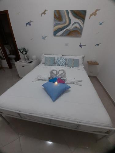 a large white bed with a blue bow on it at Falanga Family Guests Accommodation in Civitavecchia