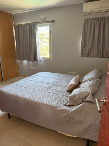 a bedroom with a bed with pillows and a window at Pueblo Maschwitz in Ingeniero Maschwitz