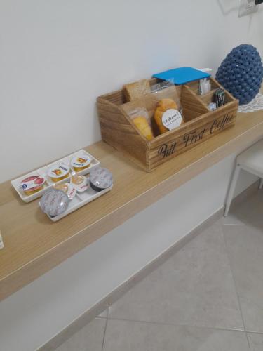 a counter with a box of donuts and a basket of food at Falanga Family Guests Accommodation in Civitavecchia