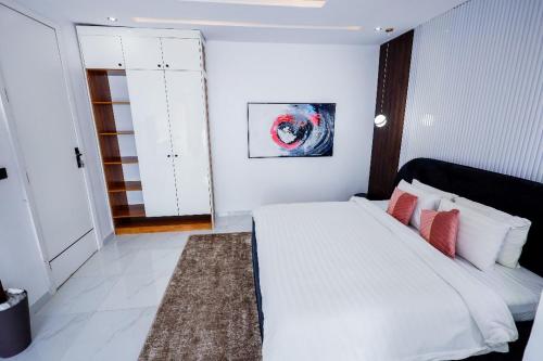 Un dormitorio con una gran cama blanca con almohadas rojas. en 4 bedroom penthouse, en Lekki