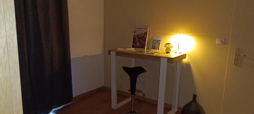 a room with a table with a light on it at Au Romarin in Cavaillon