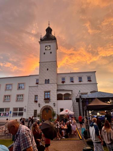 a clock tower in front of a building with a crowd of people at Apartmán Kyjov in Kyjov