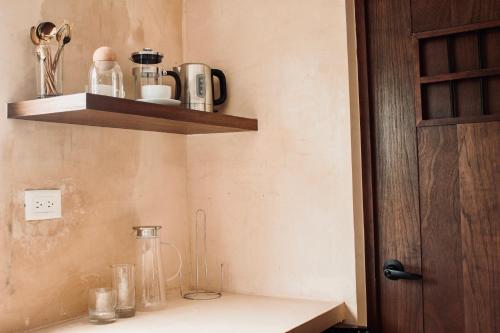a kitchen counter with a shelf on the wall at Hotel Casa Nudo, Chukum, Mérida in Mérida